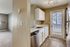 Aurora, CO, Apartments Near University of Colorado Hospital - Canterra at Fitzsimons - Kitchen With White Cabinets, Stainless Dishwasher, Speckled Countertops, and Patio Door With Blinds.