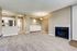 Aurora, CO, Apartments Near Cherry Creek State Park - Canterra at Fitzsimons - Spacious Living Room With Plush Carpet, Fireplace, Kitchen Pass-Through Bar, Neutral Walls, and Built-In Storage.