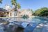 Westchase, TX, Apartments Near Westpark Tollway - Gramercy Park - A Resort Style Swimming Pool With Clear Blue Water, Stone Decking, And Palm Trees.