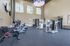 Westchase, TX, Apartments Near West Oaks Mall - Gramercy Park - A Fitness Center With Stationary Bikes, Elliptical Machines, Strength Training Equipment, Televisions, And Large Wall Mirror.