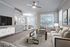 Apartments in Westchase, TX, with In-Unit Washer and Dryer - Gramercy Park - A Living Room With Gray Sofa, Glass Coffee Table, Wall-Mounted Television, Ceiling Fan, And Large Windows.