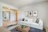 Glendale Heights, IL, Apartments Near Chicago O&rsquo;Hare Airport - Ellyn Crossing Apartments - Living Room With Sofa, Round Coffee Table, Mirror, and Sliding Glass Door With Patio View.