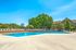 Glendale Heights, IL, Apartments for Rent - Ellyn Crossing Apartments - Outdoor Swimming Pool With Sundeck, Lounge Chairs, Metal Fence, Trees, and Apartment Views.