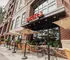 Inviting tapas bar with charming outdoor seating under umbrellas, nestled in a vibrant urban setting.