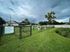Inviting dog park with agility equipment and lush green landscaping, surrounded by a safe, fenced area.