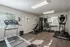 Bright and welcoming fitness center with modern equipment, featuring a treadmill and home gym setup.