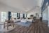 Spacious community clubhouse with high ceilings, elegant hardwood floors, and modern decor featuring large windows and comfortable seating area.