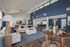 Elegant open-concept community clubhouse with navy blue accent wall, plush white sofas, and stylish decor.