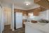 Bright kitchen with modern wood cabinets, white appliances, and sleek countertops.