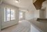 Inviting living room with large windows, plush carpet, and a sleek countertop.