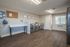 Spacious laundry room featuring multiple stainless steel washing machines and a sleek utility sink.