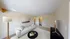 Bright and modern living room with elegant beige walls, stylish white sofa, and sleek black table, perfect for relaxation and entertainment.