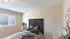 Cozy bedroom with elegant carved headboard, soft ambient lighting, and a tranquil view through large window blinds.