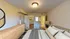 Inviting bedroom with cozy bedding, modern wooden dresser, and a spacious walk-in closet, perfect for stylish living.