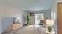 Bright and airy living room with modern decor, featuring a comfortable sofa, stylish coffee table, and a large sliding glass door leading to a balcony with a scenic view.