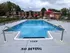 Inviting outdoor pool with red umbrellas and sun loungers, perfect for relaxation and leisure.