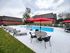 Inviting community pool area with vibrant red umbrellas, modern lounge chairs, and lush green surroundings, perfect for relaxation and socializing.