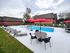 Inviting outdoor pool area with elegant lounge chairs and vibrant red umbrellas, perfect for relaxation and entertainment.