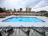 Inviting outdoor swimming pool with lounging chairs, red umbrellas, and scenic views for a perfect relaxation spot.
