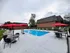 Inviting outdoor pool area with vibrant red umbrellas, relaxing lounge chairs, and stylish patio furniture, perfect for enjoying sunny days.