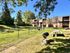 Charming garden-view apartment complex with lush green spaces, picnic area, and beautiful mature trees.