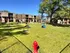 Vibrant apartment community featuring a spacious dog park with agility equipment, lush green grass, and modern brick buildings in the background.