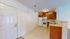 Charming kitchen and dining area with modern appliances, elegant lighting, and warm wooden cabinets in a cozy apartment.