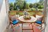 Charming balcony with stylish outdoor seating, bright cushions, and a scenic garden view, perfect for relaxing mornings.