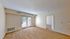 Bright and inviting living space featuring plush carpeting, elegant trim, and abundant natural light from a large patio door.