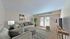 Bright and inviting living room with modern decor, plush seating, and elegant access to natural light through large windows.