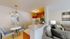 Inviting open-concept living and dining area with cozy seating, elegant lighting, and a compact kitchen ideal for modern living.