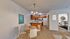 Charming open-concept apartment featuring a cozy dining area, stylish kitchen with wooden cabinets, and a welcoming living room with artistic decor.