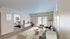 Bright and inviting living room with modern decor, plush sofas, and a large window letting in natural light, perfect for relaxation.