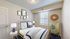 Charming and cozy bedroom with modern decor, featuring a comfortable bed with navy accents, artistic wall prints, and a nature-inspired dresser for a tranquil vibe.