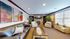 Inviting living room with a cozy fireplace, elegant leather sofa, and vibrant artwork creating a warm atmosphere.