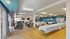 Bright and spacious community room with modern decor, featuring cozy seating areas and elegant tables set for gatherings.