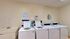 Modern laundry room featuring convenient washers and dryers with clear usage instructions, bright and inviting atmosphere.
