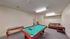 Inviting recreation room featuring a vibrant pool table, cozy seating, and elegant decor for ultimate relaxation and entertainment.