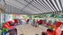 Inviting outdoor patio with vibrant red cushioned wicker furniture, situated under a stylish striped canopy, offering a perfect blend of comfort and elegance for relaxation.
