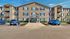 Inviting residential building with modern design, beautifully landscaped entrance, and convenient parking.