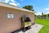 Charming outdoor dog spa area with grooming station surrounded by lush greenery and blue skies.