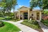 Charming apartment entrance surrounded by lush greenery and vibrant landscaping, offering a welcoming and serene atmosphere.