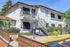 Modern two-story apartment building with stylish entrance and landscaped surroundings.
