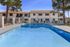Bright and inviting apartment community pool with lounge chairs and surrounding greenery.