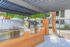 Elegant outdoor grilling station with stainless steel grills and wooden accents beneath a pergola.
