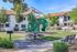 Inviting community playground with lush greenery and modern play equipment.