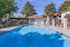 Lush outdoor community pool area with relaxing lounge chairs and vibrant greenery.