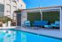 Chic outdoor seating area with cozy blue furniture by a sparkling pool, perfect for relaxation and entertainment.