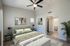Inviting bedroom with stylish decor, featuring a plush bed, elegant nightstands, modern ceiling fan, and an en-suite bathroom.