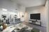 Modern open-concept living and dining area with sleek kitchen, stylish decor, and high ceilings.